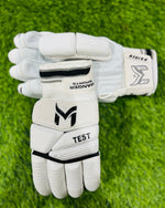 Manger Test Edition batting gloves with black and white design, padded palms, and adjustable wrist straps.