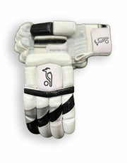 Black and grey Kookaburra batting gloves with padded palms and adjustable wrist straps for cricket protection.